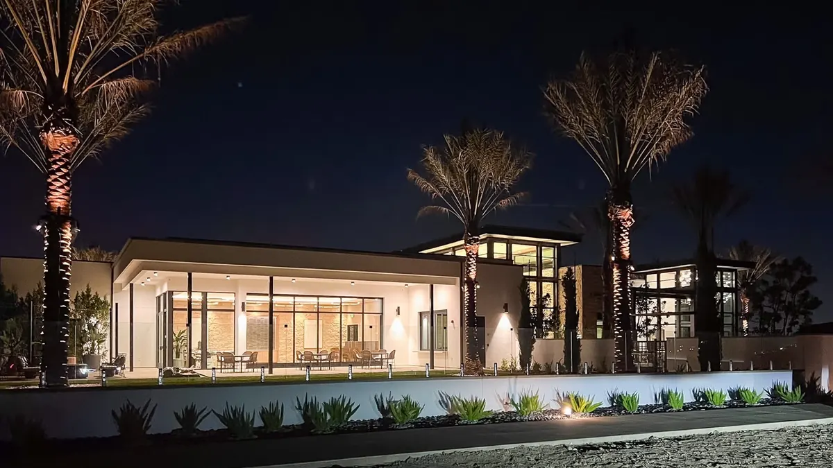 The clubhouse lit from inside against a black-blue sky.